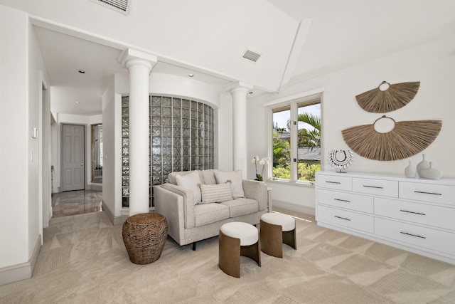 sitting room featuring light carpet, decorative columns, visible vents, and baseboards