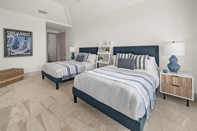 bedroom with lofted ceiling, visible vents, and light colored carpet