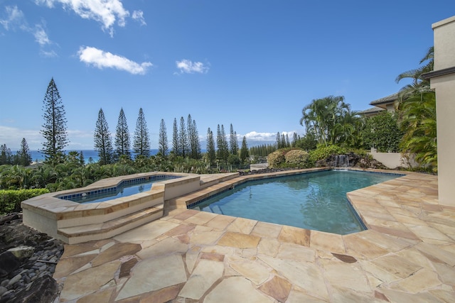 outdoor pool with a patio and an in ground hot tub