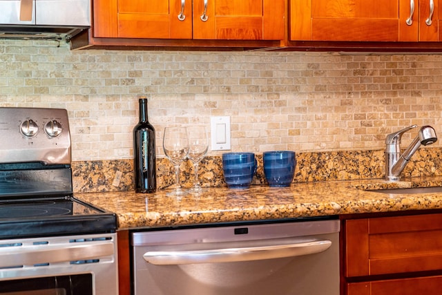 kitchen featuring tasteful backsplash, stainless steel appliances, light stone countertops, and sink