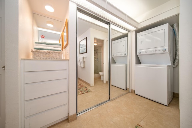 clothes washing area with stacked washer / dryer and light tile patterned floors