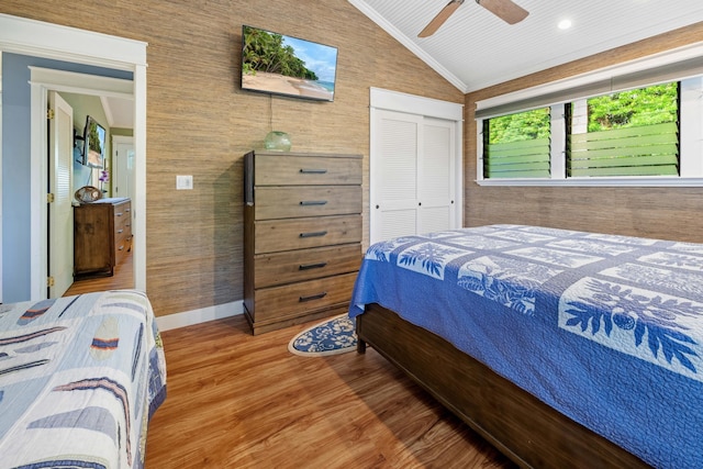 bedroom featuring wood finished floors, a ceiling fan, baseboards, vaulted ceiling, and a closet