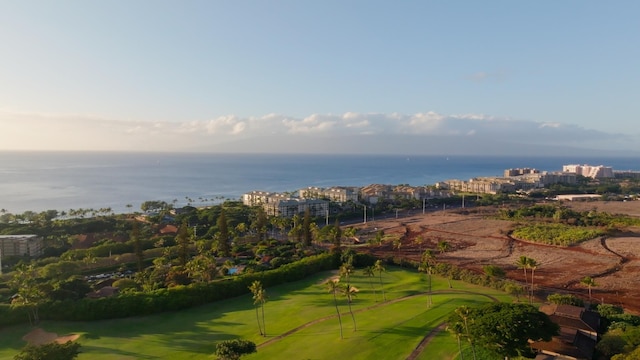 drone / aerial view with a view of city, view of golf course, and a water view