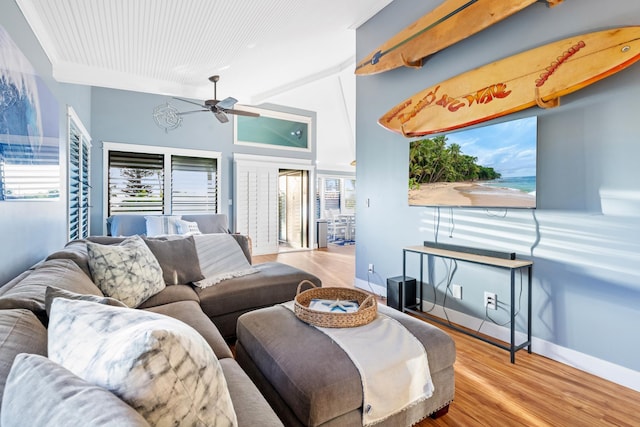 living area featuring light wood-type flooring, a ceiling fan, and baseboards