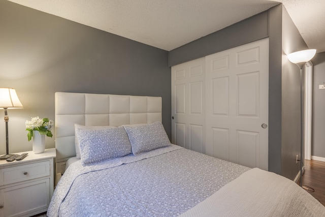 bedroom with a closet, baseboards, and dark wood-type flooring