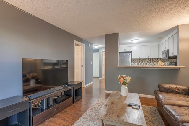 living room featuring wood-type flooring and a textured ceiling