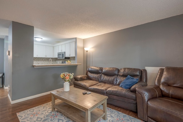 living room with a textured ceiling and dark hardwood / wood-style floors