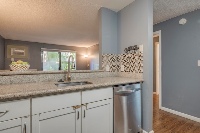 kitchen with dark hardwood / wood-style flooring, sink, white cabinets, stainless steel dishwasher, and a textured ceiling