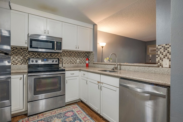 kitchen with white cabinets, sink, tasteful backsplash, stainless steel appliances, and dark hardwood / wood-style floors