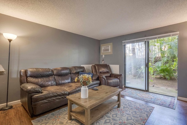 living area with a textured ceiling, wood finished floors, and baseboards