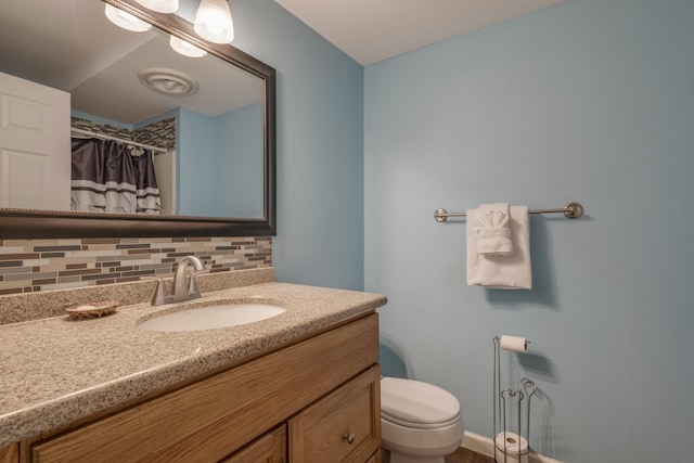 bathroom featuring a shower with shower curtain, toilet, vanity, and decorative backsplash