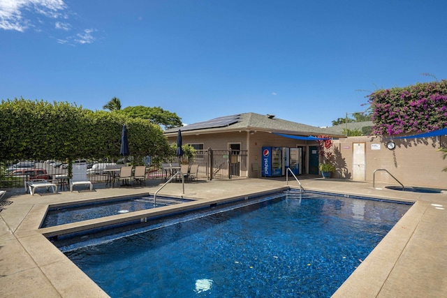 pool with a community hot tub, a patio area, and fence