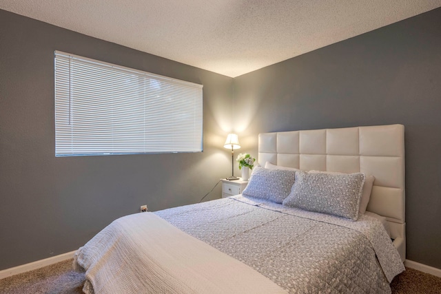 bedroom featuring a textured ceiling and carpet flooring