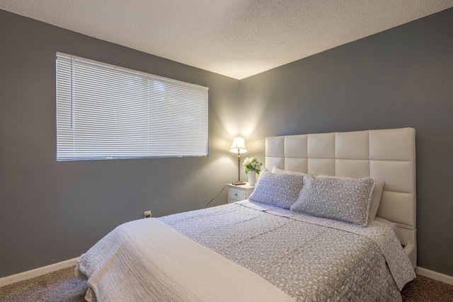 carpeted bedroom with baseboards and a textured ceiling