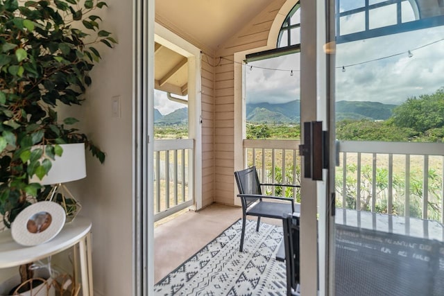 entryway with carpet floors, vaulted ceiling, and a mountain view