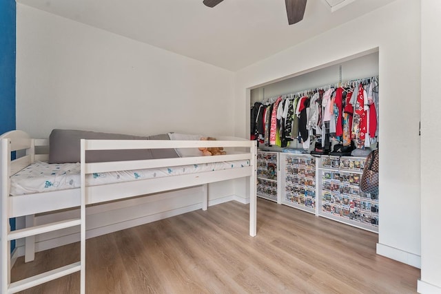 bedroom with a closet, a ceiling fan, and wood finished floors