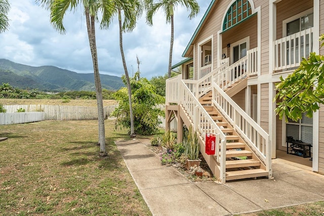 view of yard featuring a mountain view, stairway, and fence