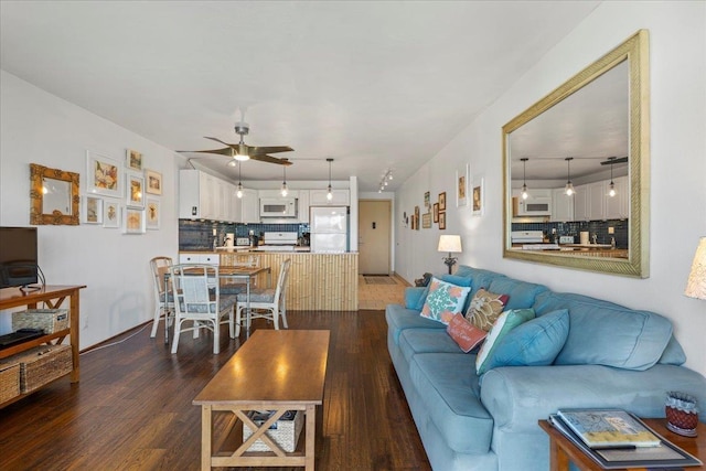 living room with dark wood-type flooring and ceiling fan