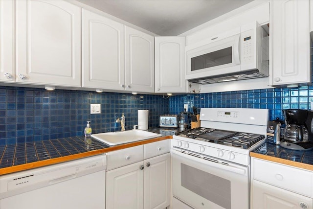 kitchen with sink, white cabinetry, tile countertops, white appliances, and decorative backsplash