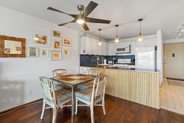 dining space with dark wood-type flooring and ceiling fan