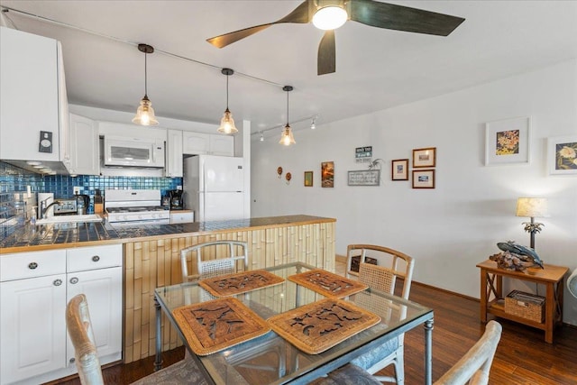 dining room featuring sink, dark wood-type flooring, and ceiling fan