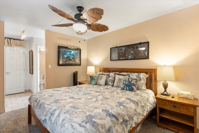 bedroom featuring ceiling fan, ensuite bath, and light tile patterned floors