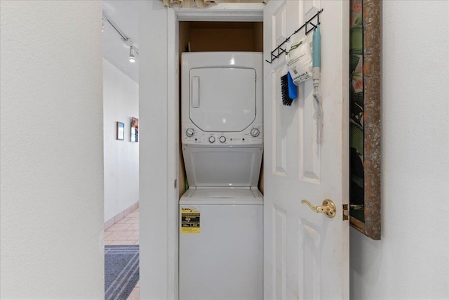 clothes washing area featuring stacked washer and clothes dryer