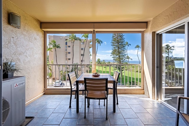 sunroom featuring a water view and ac unit