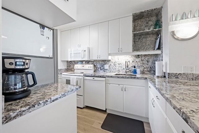 kitchen featuring white cabinets, backsplash, light wood-type flooring, sink, and white appliances