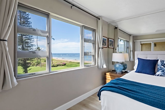 bedroom featuring a water view and multiple windows