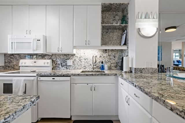 kitchen featuring light stone countertops, sink, white cabinets, and white appliances