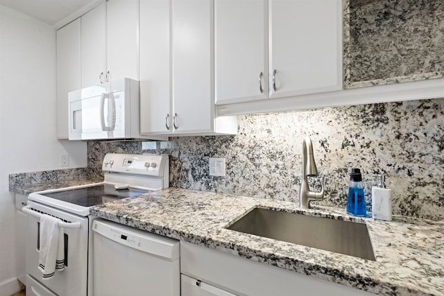 kitchen with light stone countertops, sink, white cabinetry, and white appliances