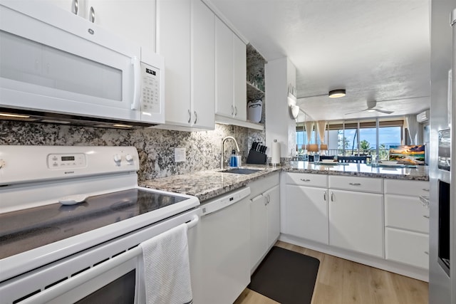 kitchen with light hardwood / wood-style flooring, sink, white cabinets, light stone counters, and white appliances