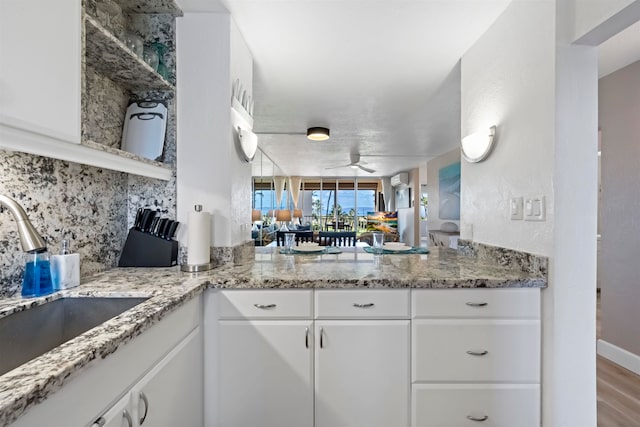 kitchen featuring ceiling fan, sink, light wood-type flooring, and white cabinets