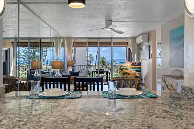 dining area featuring a wall unit AC and ceiling fan