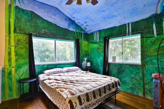 bedroom with multiple windows, wood-type flooring, lofted ceiling, and ceiling fan