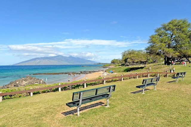 view of home's community featuring a water and mountain view and a lawn