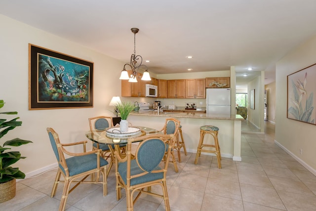 dining room featuring light tile patterned floors, sink, and an inviting chandelier