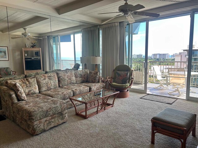 living room featuring ceiling fan, beam ceiling, and plenty of natural light