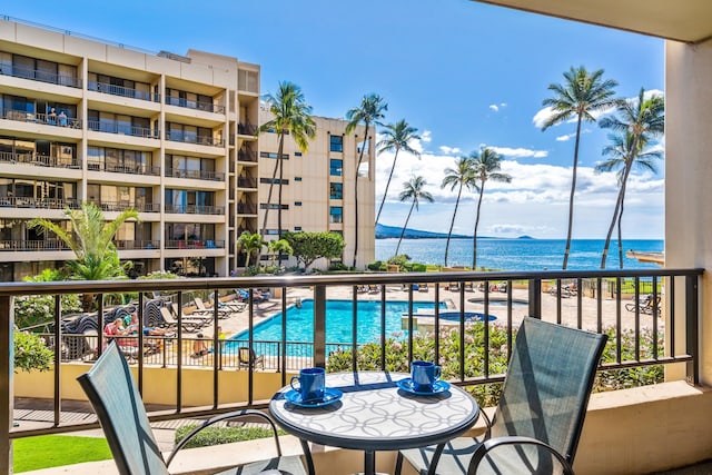 balcony with a community pool and a water view