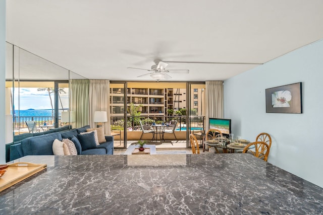 living room featuring expansive windows and ceiling fan