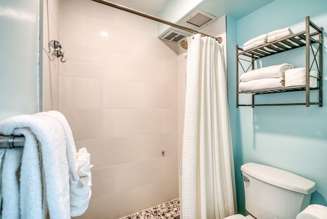 bathroom with toilet and a shower with shower curtain