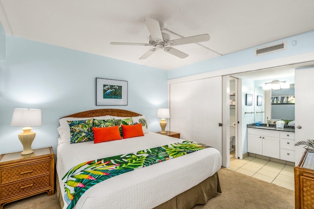 tiled bedroom featuring ensuite bath, ceiling fan, and sink