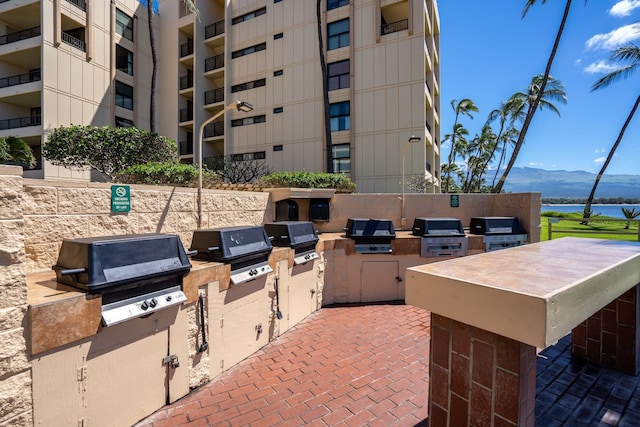 view of terrace with a balcony, area for grilling, and a mountain view