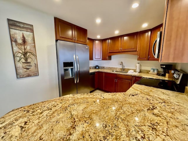 kitchen featuring light stone countertops, sink, and appliances with stainless steel finishes