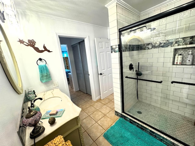 bathroom with tile patterned flooring, vanity, a shower with shower door, and crown molding