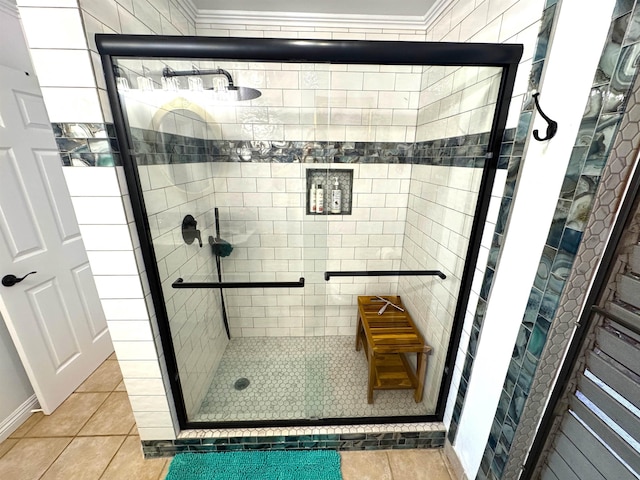 bathroom featuring tile patterned flooring, a shower with door, and crown molding