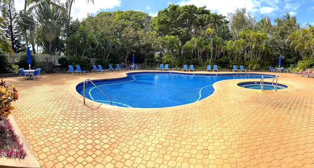 view of pool with a patio and a hot tub