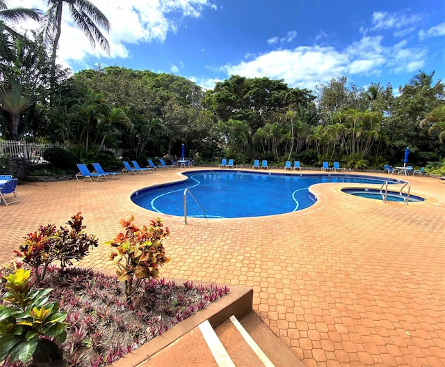 view of swimming pool featuring a patio area and a hot tub