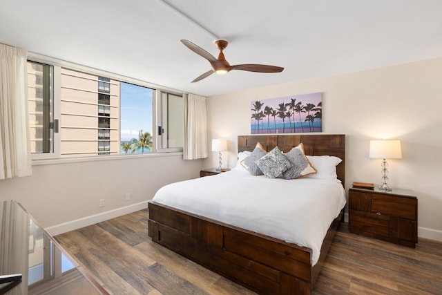 bedroom featuring a ceiling fan, baseboards, multiple windows, and wood finished floors